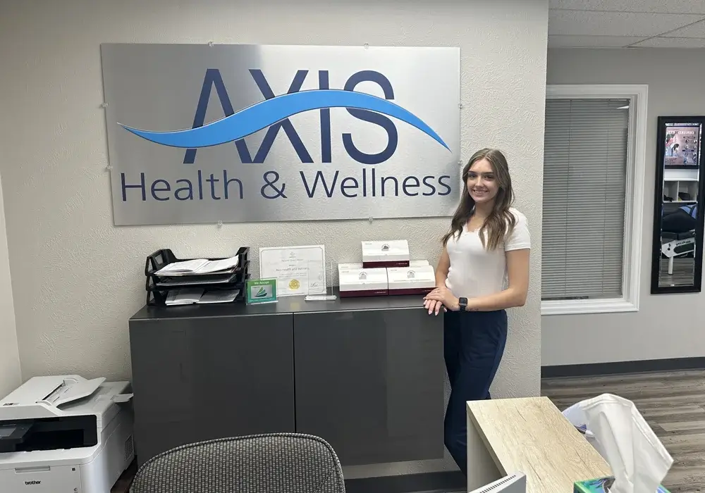 Chiropractor explaining spinal conditions on a spine model at Axis Health and Wellness in Centennial