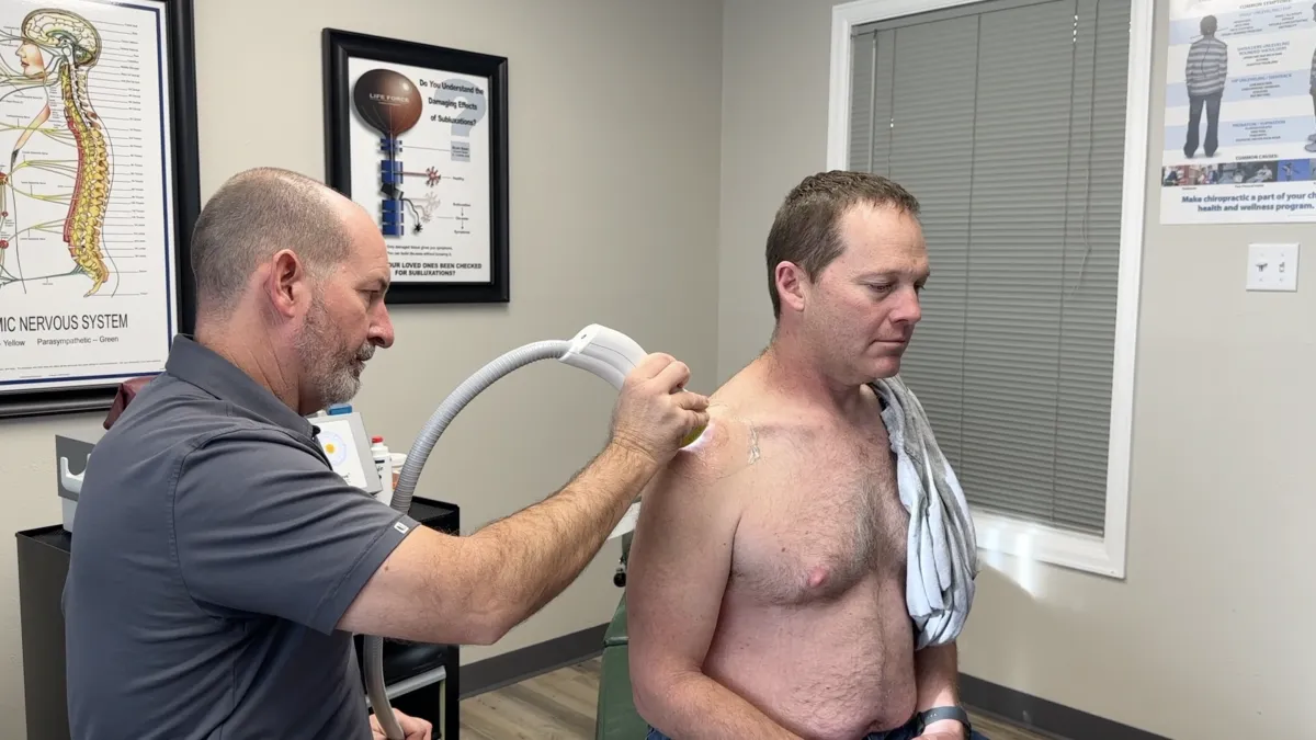 SoftWave therapy applicator being used on a patient's knee at Axis Health and Wellness in Centennial CO