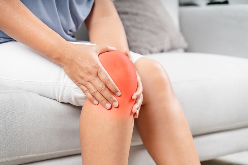 Woman suffering from knee pain seeking chiropractic care at Axis Health and Wellness in Centennial CO