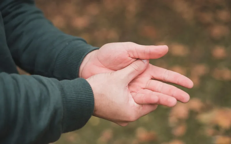 Man squeezing his hand from numbness and tingling in his fingers in Centennial CO