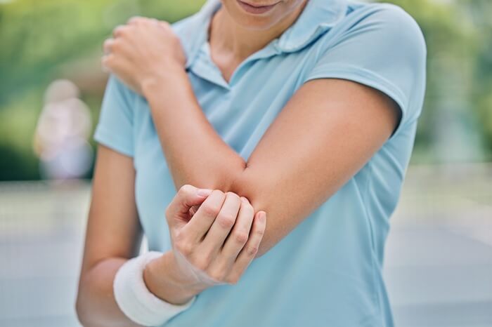 Athlete with elbow pain from a sports injury treated at Axis Health and Wellness in Centennial CO